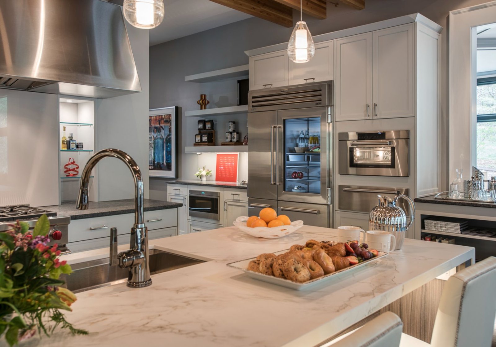 custom home builder Wayne pa - design home studios - underlit cabinets - stainless steel appliances - red stove knobs - exposed beams - pastries