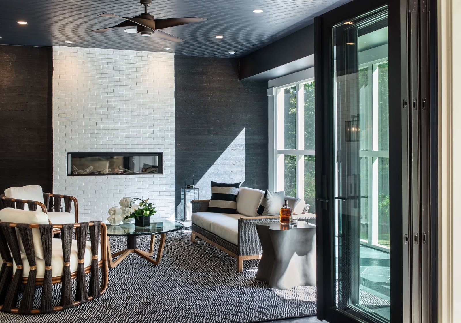 custom home builder Philadelphia pa - white brick fireplace - outdoor area - black and white patio furniture