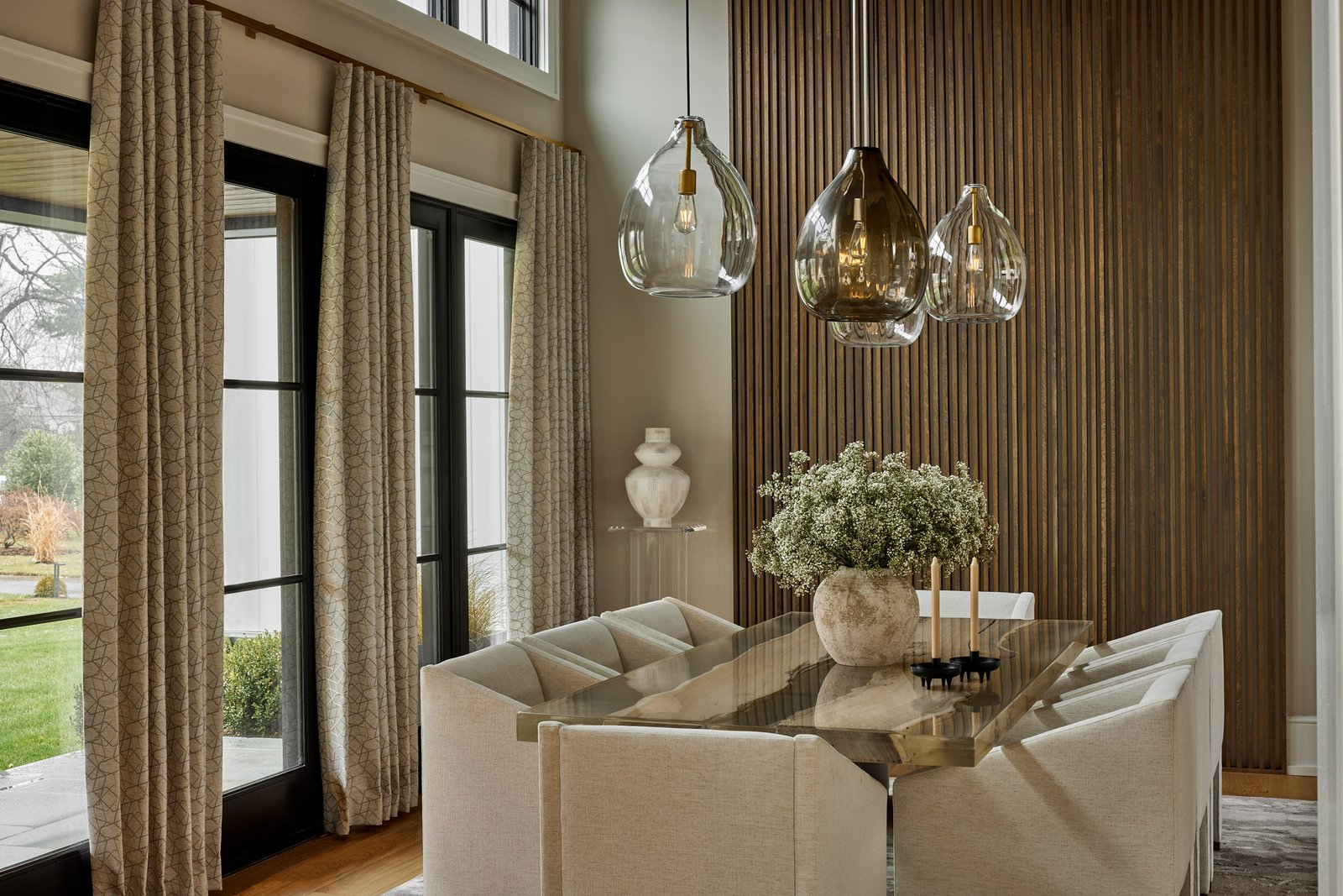 new homes Philadelphia pa - design home studios - neutral dining room - beige chairs - glass table - wooden accent wall - best custom home builder Wayne pa